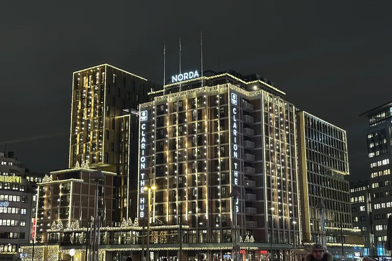 Clarion Hotel The Hub lit up at night, its name in tall letters down the corner of the building.