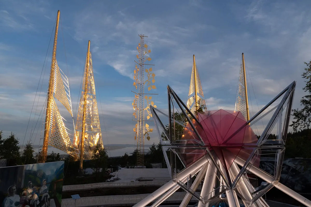 Roseslottet at dusk: gilded steel spires lit against the evening sky on the hill above Oslo.